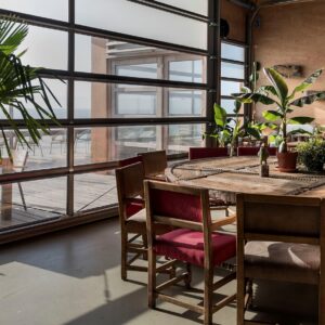 ronde houten vergadertafel met stoelen met suede zichtbaar met uitzicht door de ramen van de zee